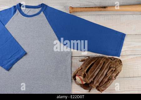 Alta angolazione di un baseball jersey con una sfera e un guanto e bat su una superficie di legno. Foto Stock