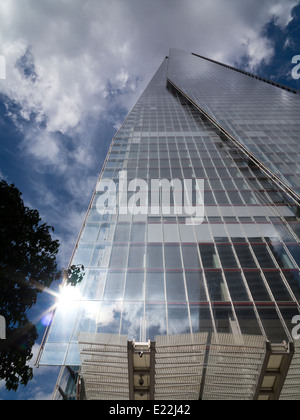 Un ampio angolo del London Shard contro una drammatica del bianco e del blu cielo con un sole luminoso riflesso nell'angolo inferiore sinistro Foto Stock