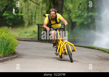 Noleggio messenger con carico accelerando la bici per la consegna Foto Stock