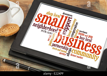 Small business word cloud su una tavoletta digitale con una tazza di caffè Foto Stock