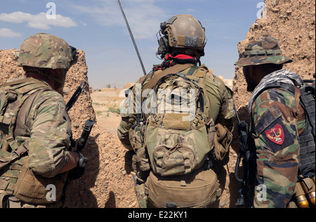 US Army delle forze speciali militari assegnati a Combined Joint Special Operations Task Force con l esercito nazionale afgano forze speciali soldato con la terza le Operazioni Speciali Kandak durante un'operazione di compensazione 2 Giugno 2014nel villaggio Karezak, Maiwand distretto, provincia di Kandahar, Afghanistan. Foto Stock