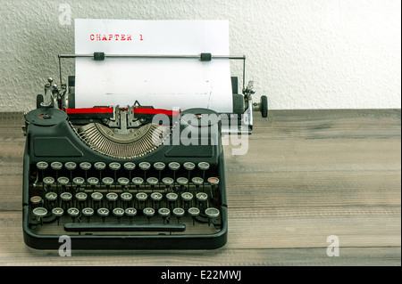 Nastri inchiostratori per macchine da scrivere con carta bianca pagina su un tavolo di legno. un campione del testo del capitolo 1 Foto Stock