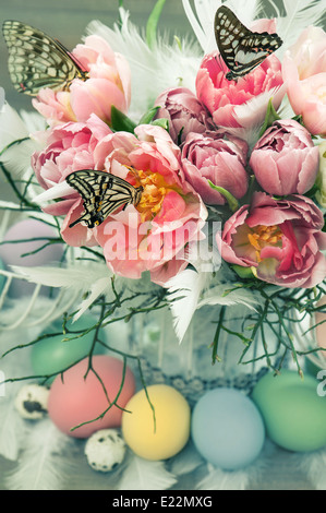 Decorazione di pasqua con il rosa tulip fiori e farfalle e uova colorate Foto Stock