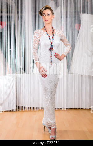 Donna cerca su abiti da sposa o abito nuziale in wedding fashion store Foto Stock