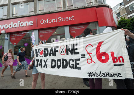 Oxford Street, Londra, Regno Unito. 14 giugno 2014. Attivisti provenienti da Regno Unito intonso, messa a fuoco E15 & DPAC trasformato l'ingresso ad un Vodafone nel negozio di Oxford Street, Londra, in una festa con palloncini, paracadute giochi per bambini, Twister e un asilo nido. La protesta è in risposta al rivenditore la presunta corporation evasione fiscale a partire dal 2011 e a causa di 6 miliardi di sterline in tasse derivanti dal 2000. Credito: Lee Thomas/Alamy Live News Foto Stock