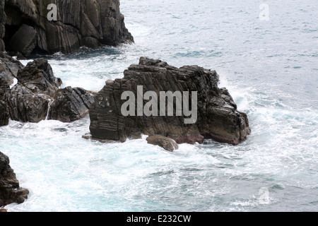 Onde che si infrangono sulle rocce Foto Stock