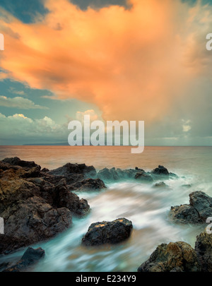 Sunrise e nuvole sulla spiaggia rocciosa. Maui, Hawaii Foto Stock