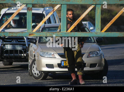 Hebron, West Bank. Il 15 giugno, 2014. Soldati israeliani bloccare una strada durante una operazione militare per cercare tre mancano giovani israeliani vicino al West Bank città di Hebron, il 15 giugno 2014. Il Primo Ministro israeliano Benjamin Netanyahu ha detto che i giovani ebrei erano stati rapiti nella West Bank da parte di un'organizzazione terroristica. Credito: Mamoun Wazwaz/Xinhua/Alamy Live News Foto Stock