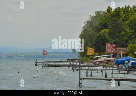 Neuchâtel, Svizzera. Il 15 giugno, 2014. Venti forti pastella riva e mantenere bandiere rigide sul lago di Neuchâtel. Dopo una settimana di estate-come calore, previsioni locali stanno chiamando per i forti venti e le temperature dello scambiatore di calore. Credito: Ted Byrne/Alamy Live News Foto Stock