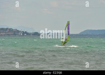 Neuchatel, Svizzera. Il 15 giugno, 2014. Un windsurfer solitario naviga tra gli scatti, acque color smeraldo del lago di Neuchâtel. Dopo una settimana di estate-come calore, i forti venti sono un gradito cambiamento in riva al lago per gli amanti dello sport. Credito: Ted Byrne/Alamy Live News Foto Stock