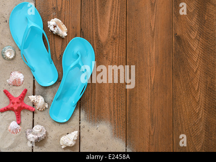 Concetto di vacanza. Blue Flip-flop con stella rossa su sfondo di legno con copia spazio, vista dall'alto Foto Stock