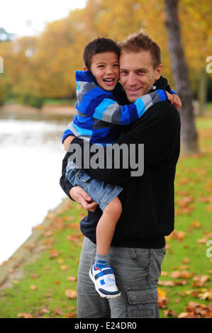Padre con suo figlio tra le sue braccia. Foto Stock