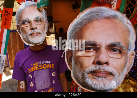 Un ragazzo giovane e maschere con l'attuale primo ministro indiano Narendra Modi durante il 2014 le elezioni generali in Mumbai, India. Foto Stock