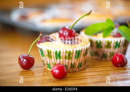 Formaggio muffin con ciliegie e rametto di menta Foto Stock