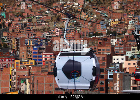 La Paz in Bolivia. 16 Giugno, 2014. Una gondola nella forma di un pallone da calcio viaggi sul nuovo cavo auto / cabinovia di collegamento tra sistema di La Paz e El Alto. Diverse le gondole sono state modificate per una progettazione di calcio per celebrare la Coppa del Mondo 2014 attualmente detenute in Brasile. La prima delle tre linee della cabinovia è stato inaugurato il 30 maggio 2014, in totale essi costituiranno la più lunga e la più alta sistema di cabinovia urbana nel mondo. Credito: James Brunker / Alamy Live News Foto Stock