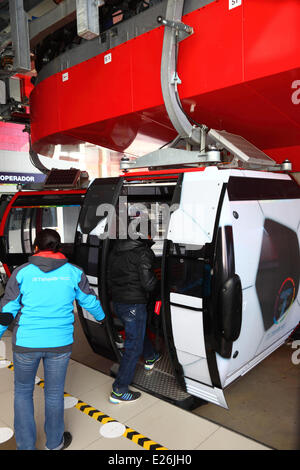 La Paz in Bolivia. 16 Giugno, 2014. Un uomo commissioni una gondola sotto forma di un campo di calcio nel terminale di El Alto, sul nuovo cavo auto / cabinovia che collega il sistema di El Alto a La Paz. Diverse le gondole sono state modificate per una progettazione di calcio per celebrare la Coppa del Mondo 2014 attualmente detenute in Brasile. La prima delle tre linee della cabinovia è stato inaugurato il 30 maggio 2014, in totale essi costituiranno la più lunga e la più alta sistema di cabinovia urbana nel mondo. Credito: James Brunker / Alamy Live News Foto Stock