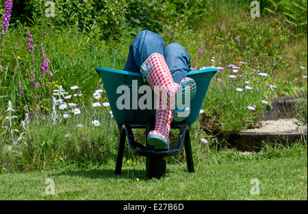 Posa femmina in giardino carriola Foto Stock