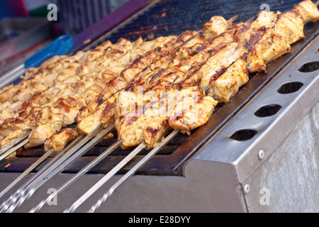 Una fila di pollo shish kebab cottura alla griglia Foto Stock