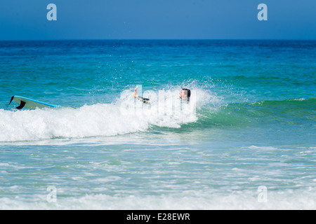 Un surfista in St Ives, Cornwall, Inghilterra, cadendo dal loro tavola da surf. Foto Stock