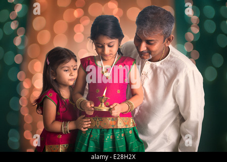 Famiglia indiana fagther e figlia celebrare diwali ,fesitval di luci all'interno di un tempio Foto Stock