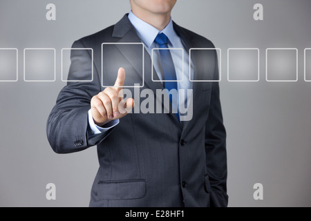 Business man spingendo su una interfaccia touch-screen Foto Stock