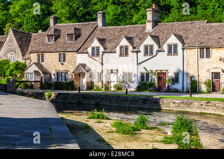 Una fila di graziosi cottage terrazzati lungo il fiume Bybrook nel villaggio Costwold di Castle Combe nel Wiltshire. Foto Stock