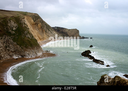 Il Dorset Crumple, Chalk Cliffs e pietra di Portland 'man di guerra' pila dalla porta di Durdle, Lulworth, Dorset con scuotipaglia sulla spiaggia Foto Stock