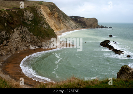 Il Dorset Crumple, Chalk Cliffs e pietra di Portland 'man di guerra' pila dalla porta di Durdle, Lulworth, Dorset con scuotipaglia sulla spiaggia Foto Stock