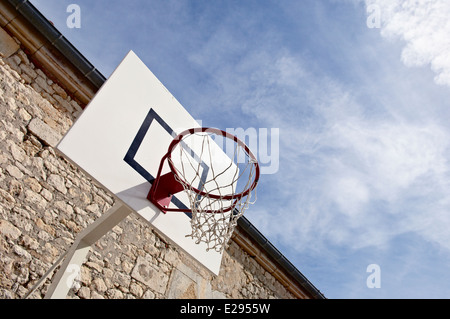 Basketball hoop contro un cielo nuvoloso. Foto Stock