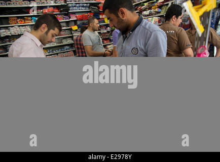 Tehran, Iran. 16 Giugno, 2014. Un cliente iraniano si affaccia su Iran la nazionale di calcio abito per 2014 FIFA World Cup, mentre lo shopping nel centro di Teheran. Credito: Morteza Nikoubazl/ZUMA Press/Alamy Live News Foto Stock