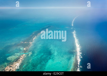 Vista aerea di onde che si infrangono sulla barriera corallina al largo delle coste orientali dalla belize in america centrale nel mar dei Caraibi Foto Stock