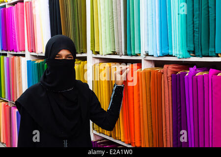 India Andhra Pradesh, Hyderabad, Laad bazar, donna velata in un tessuto tessile shop Foto Stock