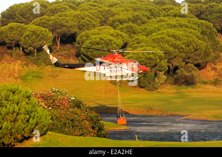 Bell 412 elicottero (registrazione N167EH) raccolta di acqua per la lotta contro gli incendi da un campo da golf lago, Cabopino Golf, Andalusia. Foto Stock