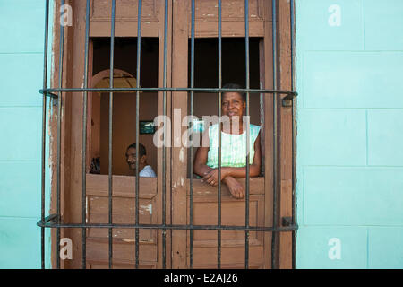 Cuba, Sancti Spiritus Provincia, Trinidad de Cuba, classificato come patrimonio mondiale dall UNESCO, donna in piedi dalla finestra di un Foto Stock