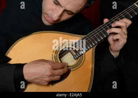 Close up di persona a suonare la chitarra portoghese durante una performance Fado Foto Stock