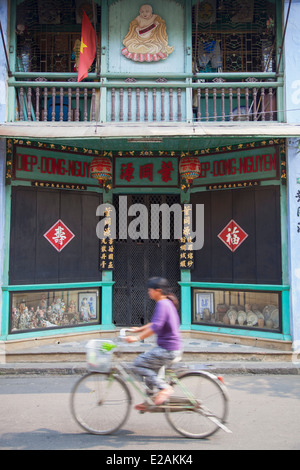 Donna Bicicletta Equitazione passato negozio cinese anteriore, Hoi An (Patrimonio Mondiale dell'UNESCO), Quang prosciutto, Vietnam Foto Stock