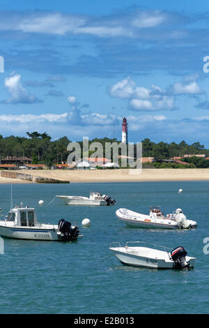 Francia, Gironde, Baia di Arcachon, Cap Ferret, Plage du Phare, barche a motore che sono ancorate al largo della spiaggia di fronte di un faro Foto Stock