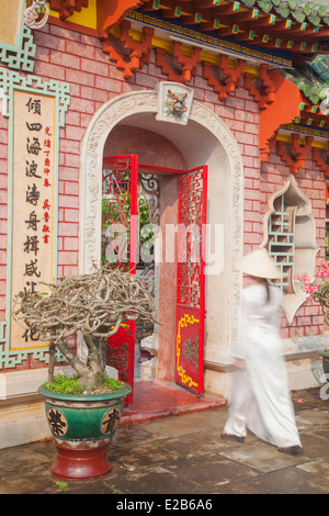 Donna che indossa Ao Dai abito a Phouc Kien Assembly Hall, Hoi An (Patrimonio Mondiale dell'UNESCO), Quang prosciutto, Vietnam Foto Stock