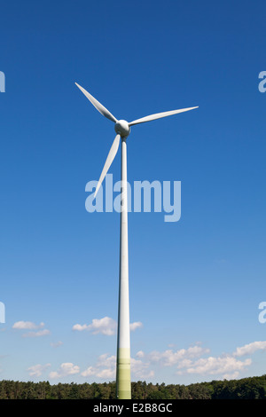 Turbina eolica contro il luminoso cielo blu Foto Stock