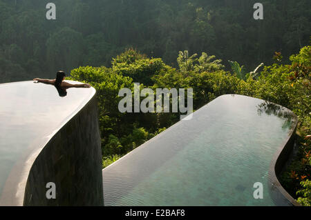 Indonesia, Bali, Gianyar, Buahan Payangan, Ubud Hanging Gardens hotel gruppo Orient-Express, una giovane donna indietro le braccia tese, piscina infinity affacciata la giungla di sunrise Foto Stock