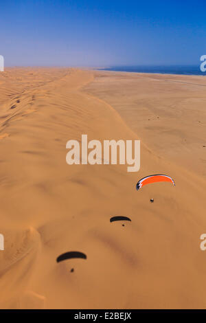 La Namibia, Regione di Erongo, tra Sawkopmund e Walvis Bay, la spiaggia e le dune di sabbia, paramotor (vista aerea) Foto Stock