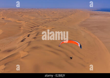 La Namibia, Regione di Erongo, tra Sawkopmund e Walvis Bay, la spiaggia e le dune di sabbia, paramotor (vista aerea) Foto Stock