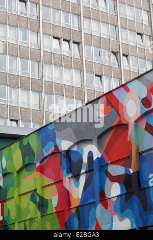 Il contrasto di coloratissimi street art graffiti a Nelson Street, Bristol con indefinibile edificio dietro Foto Stock