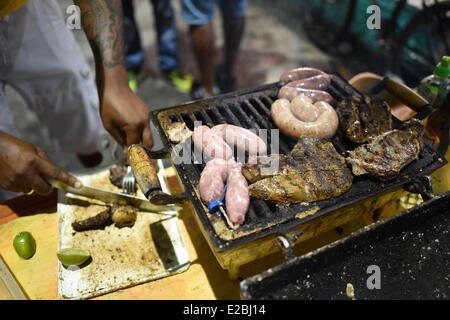 Porto Seguro, Brasile. 17 Giugno, 2014. Un uomo si prepara un barbecue dopo la Coppa del Mondo FIFA 2014 Gruppo a turno preliminare match tra il Messico e il Brasile davanti a un bar nel centro di Porto Seguro, Brasile, 17 giugno 2014. La Coppa del Mondo FIFA 2014 si svolgerà in Brasile dal 12 giugno al 13 luglio 2014. Credito: dpa picture alliance/Alamy Live News Foto Stock