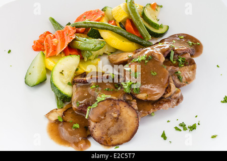 Medaglioni di manzo con salsa di funghi e medley di vegetali. Foto Stock