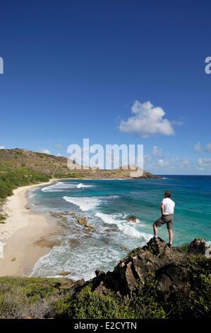 Francia Guadalupa (Indie occidentali francesi) Saint Barthelemy Toiny uomo da dietro guardando la baia in piedi su una roccia Foto Stock