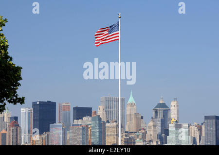 Stati Uniti, New York, bandiera americana su Ellis Island e Manhattan Foto Stock