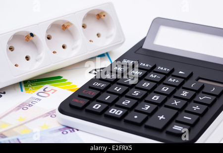 L'immagine mostra una presa di alimentazione denaro e di una calcolatrice Foto Stock