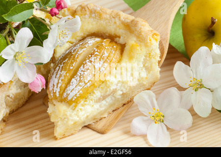 Pezzo di fatti in casa torta di mele, frutta apple blossom e ramo di albero sul tavolo da cucina Foto Stock