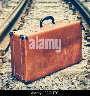 Vintage valigia marrone in piedi sulla ferrovia Foto Stock